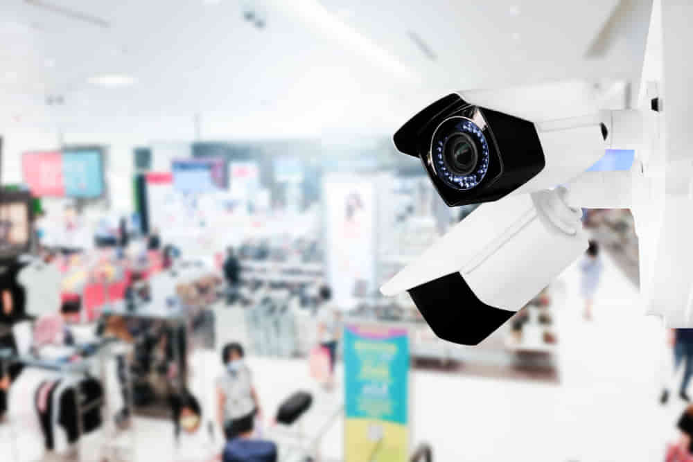 modern public cctv camera with blur interior shopping mall background and copy space